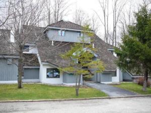 una casa con tetto grigio e vialetto di FirBear- AC, Pool, Hot Tub, Sauna, Tennis, Gym a Killington