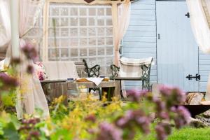a patio with a table and chairs and flowers at 5-Bed Highland Lodge - NC500 - Sleeps 10 in Alness