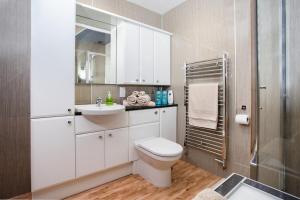 a bathroom with a toilet and a sink at Mike's 3-bedroom Countryside Cottage in Alness +47 photos