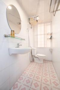 a white bathroom with a sink and a toilet at The La Renta Hotel & Spa in Hanoi