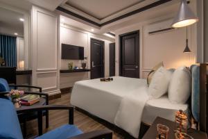 a hotel room with a white bed and a couch at Elites Hotel in Danang