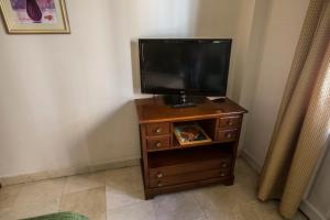 a tv on a wooden stand with a television at Apartamentos Caballero de Gracia in Madrid