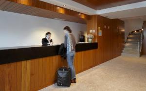 a woman standing at a counter in a lobby at Abrigo da Montanha Hotel Rural in Sabugueiro +26 photos