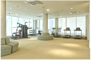 a large room with a gym with a treadmill and chairs at Modern 3BHK with Well-Equipped kitchen on 22 flr, Parking & Club House Perfect for Families in Bengaluru