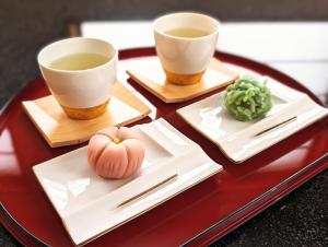 two cups of tea and vegetables on a table at ひがし茶屋街らしく金沢 Hotel Rashiku kanazawa in Kanazawa