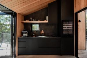 a kitchen with a black counter and a window at Hunter Huon Valley Cabin Three in Glen Huon