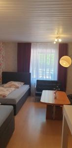 a bedroom with a bed and a table and a couch at Stadtrand Hotel in Hagen