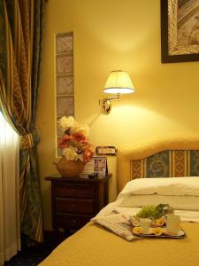 Una habitación de hotel con una cama con una bandeja de comida. en Hotel La Pace - Experience, en Cassino