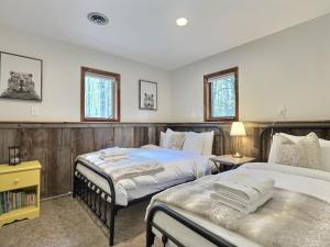 Un dormitorio con dos camas y dos ventanas. en The Big Lebearski - AC, Grill, Fire Pit, Hot tub!, en Killington