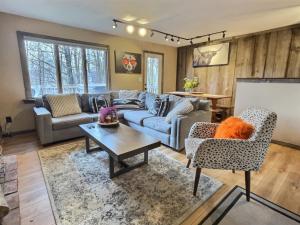 una sala de estar con un sofá y una mesa en The Big Lebearski - AC, Grill, Fire Pit, Hot tub!, en Killington