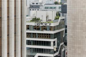 a sign on the top of a building in a city at HOTEL DRIP&DROP Myeongdong in Seoul