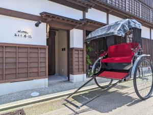 a red carriage parked in front of a building at ひがし茶屋街らしく金沢 Hotel Rashiku kanazawa in Kanazawa