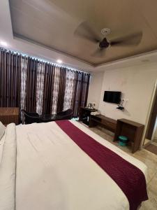 a bedroom with a large bed and a desk at Hotel mauji's legacy in Allahābād