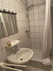 a white bathroom with a sink and a shower at Anamarija Apartments in Ličko Petrovo Selo +33 photos