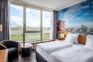 a hotel room with two beds and a large window at Crowne Plaza Antwerpen by IHG in Antwerp +136 photos