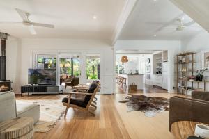 a living room with a couch and a table at Frangipani Cottage - Belle Escapes Byron Bay | Winter Escape Deal | Stay Longer & Save | 1 June – 31 August in Byron Bay