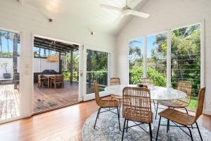 a dining room with a table and chairs at Frangipani Cottage - Belle Escapes Byron Bay | Winter Escape Deal | Stay Longer & Save | 1 June – 31 August in Byron Bay +21 photos