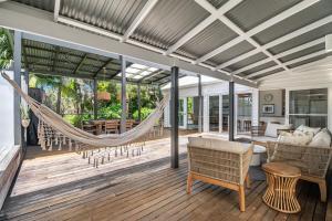a hammock on the screened porch of a house at Frangipani Cottage - Belle Escapes Byron Bay | Winter Escape Deal | Stay Longer & Save | 1 June – 31 August in Byron Bay