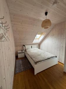 a bedroom with a white bed in a attic at Kopa Cabana in Palanga