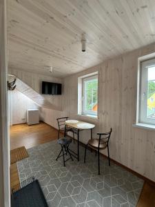 a room with a table and chairs and a tv at Kopa Cabana in Palanga
