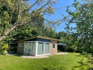 a small house in the middle of a yard at Blue House in Ouddorp