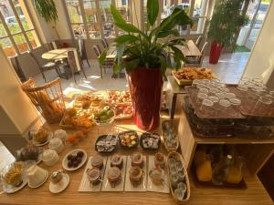 a table with a bunch of donuts and other desserts at KYRIAD ORANGE Centre Ville - HOTEL RESTAURANT BAR - Galerie d'Art des Princes - Provence Alpes Côte'Azur - France - AUTOROUTE A7-A9 - exit21- Châteauneuf-du-Pape Avignon Bollene Nimes Valence - Terrasse - Repas - Petit Déjeuner in Orange +226 photos