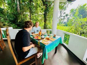 a man and woman sitting at a table with food at Rock Grand View in Ella
