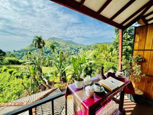 a table on a balcony with a view of the mountains at Rock Grand View in Ella
