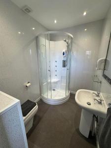 a bathroom with a shower and a toilet and a sink at The Jubilee Hotel East - with NEWLY REFURBISHED SPA FACILITIES - GAMESPIT - AND SMOKEHOUSE in Weymouth