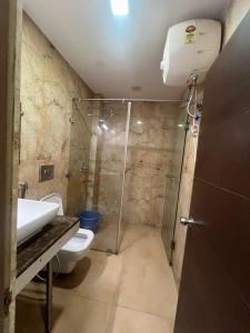 a bathroom with a shower and a toilet and a sink at Hotel mauji's legacy in Allahābād