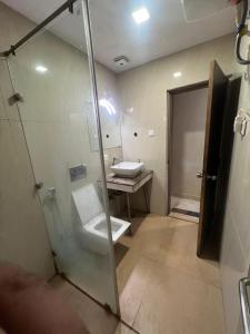 a bathroom with a glass shower and a sink at Hotel mauji's legacy in Allahābād