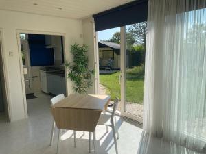 a kitchen and dining room with a table and chairs at Blue House in Ouddorp