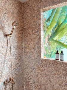 a shower in a bathroom with a painting on the wall at Villa Maison Pastis Canggu in Canggu +12 photos