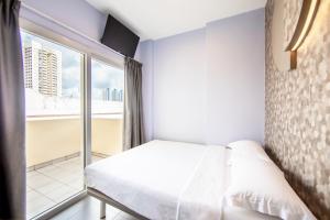 a bedroom with a bed and a large window at Fragrance Hotel - Lavender in Singapore +23 photos