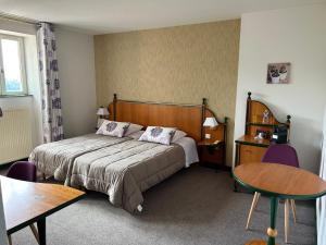 una habitación de hotel con una cama y una mesa en Le Bel Vue, en Le Cergne
