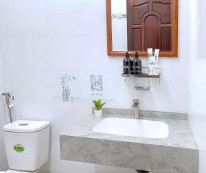 a bathroom with a sink and a toilet at Nhà Khách Vạn Thành in Cà Mau