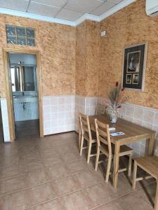a dining room with a wooden table and chairs at Hostal la Tarayuela in Barbate