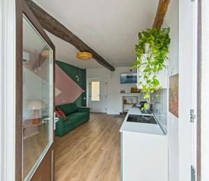 a kitchen and a living room with a green couch at LevOasi 7 - Garden, jacuzzi and sauna escape in Levo