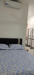 a bed with a blue comforter in a bedroom at Inaz Homestay Alor Setar in Kampong Masjid