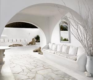 a living room with white walls and a white couch at Mykonos Bay Resort & Villas in Mikonos