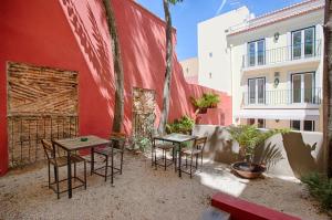 un patio con 2 mesas y sillas junto a un edificio en Dear Lisbon - Charming House, en Lisboa