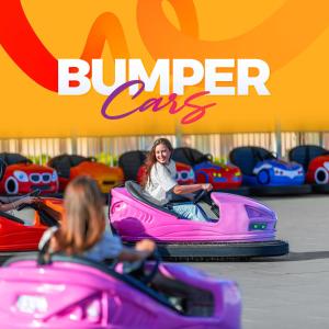 a woman is riding on a pink bumper car at Pickalbatros Jungle Aqua Park - Neverland Hurghada in Hurghada