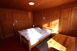 ein Schlafzimmer mit einem Bett und einem Tisch darin in der Unterkunft Chalet Les Arolles in Chateau-d'Oex
