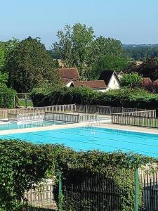 a large blue swimming pool with a fence at Maison bastide Périgord in Castillonnès