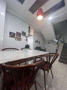 a dining room with a table and chairs and stairs at 班台民宿 185 in Pantai Remis