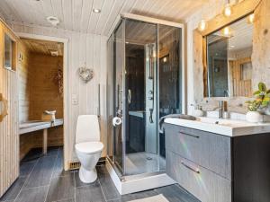 une salle de bains avec douche, toilettes et lavabo dans l'établissement 4 star holiday home in Storsteinnes, à Rundhaug 41 autres photos