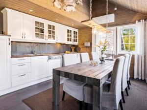 une cuisine avec une table en bois et des armoires blanches dans l'établissement 4 star holiday home in Storsteinnes, à Rundhaug
