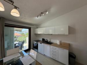 a kitchen with white cabinets and a large window at Villa Dante with swimming pool in Trogir