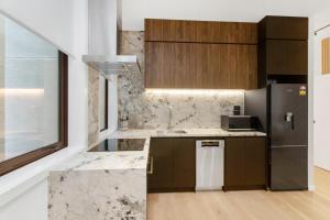cocina con encimeras de mármol y nevera en Victoria Street Apartments by Urban Rest, en Auckland