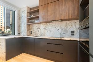Una cocina con gabinetes marrones y una ventana. en Victoria Street Apartments by Urban Rest, en Auckland 29 fotos más